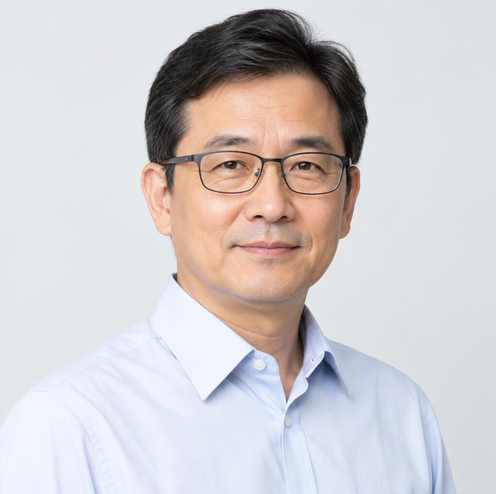 Studio portrait of an East Asian man in a shirt and glasses